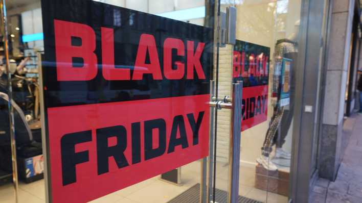 Ein Plakat mit der Aufschrift „Black Friday“ hängt in einem Schaufenster.