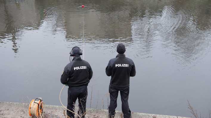 Zwei Polizisten bei der Suche nach Beweisen in einem See. (Quelle: Picture Alliance)
