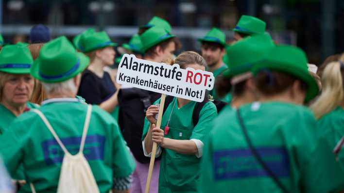 Im Rahmen des bundesweiten Protesttags der Deutschen Krankenhausgesellschaft demonstrieren Krankenhausmitarbeiter unter dem Motto "Alarmstufe Rot: Krankenhäuser in Not" (Bild: dpa / Jörg Carstensen)