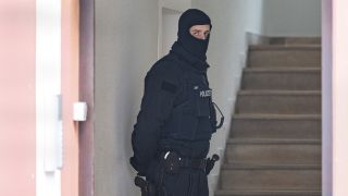 Archiv: Bei einer Razzia gegen sogenannte "Reichsbürger" sichert ein Polizist ein durchsuchtes Objekt