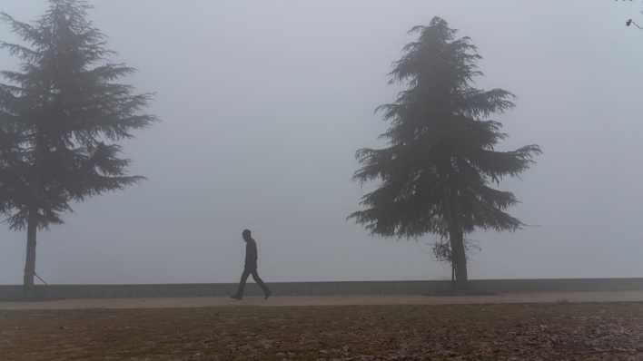Ein Mann läuft alleine durch den Nebel